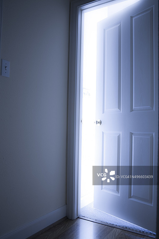 概念:用明亮的光线从另一边打开门。图片素材