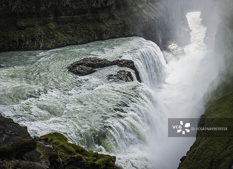 瀑布轰隆隆地穿过山河进入冰岛湾峡谷图片素材