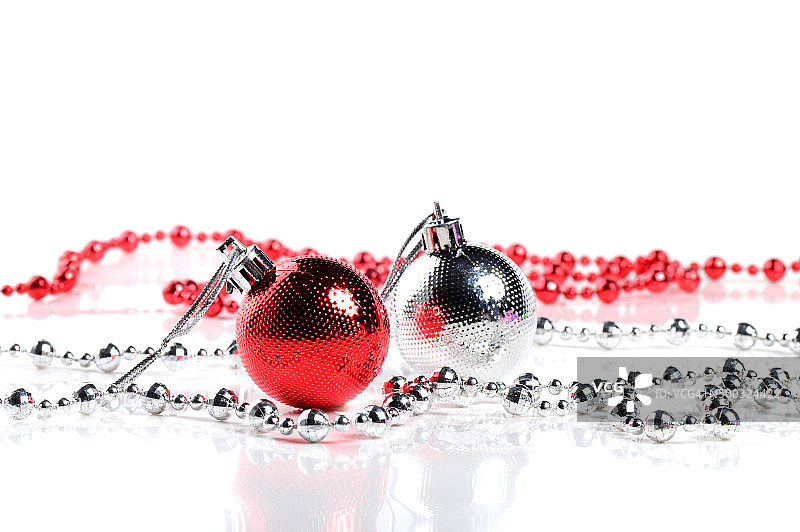 红色和银色圣诞球与装饰品在白色的背景。图片素材