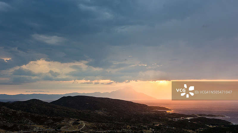 暴风雨的天空，海上的日出，环绕阿陀斯山的阳光图片素材