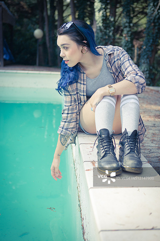 泳池边有蓝色头发纹身的女人图片素材