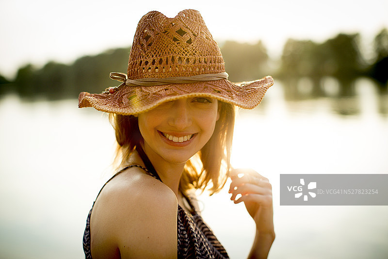戴着草帽，面带微笑的年轻女子图片素材