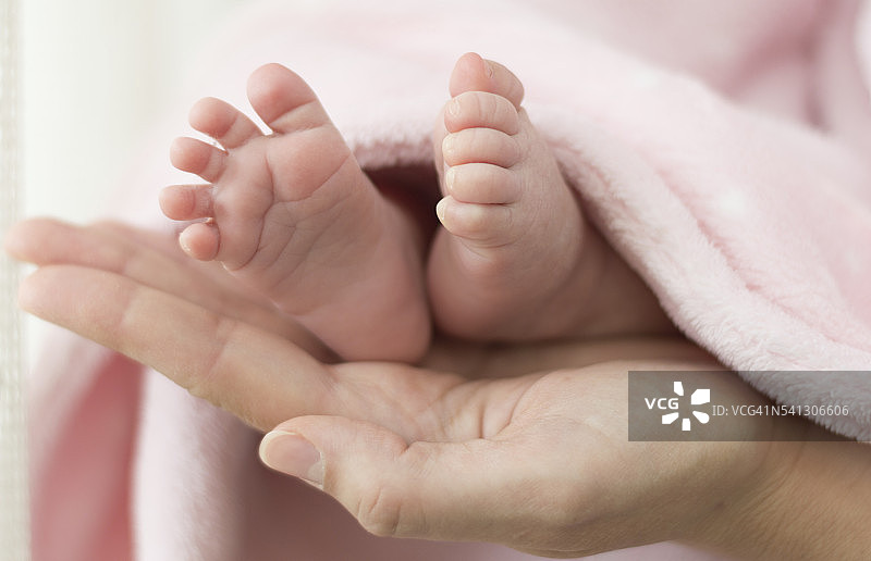 新生婴儿的脚在母亲的手中图片素材