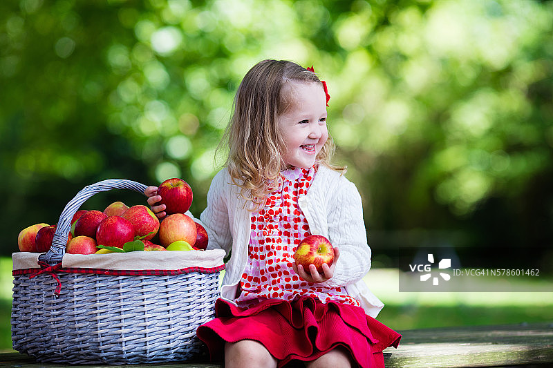快乐的小女孩拿着苹果篮子图片素材