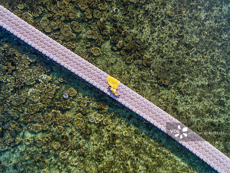 在浮桥上，身着黄色飘舞裙的女子图片素材