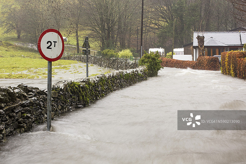 2015年12月5日星期六，在Desmond风暴带来的暴雨中，湖区的Rothay桥附近Ambleside的Under Loughrigg道路上汹涌的洪水。图片素材