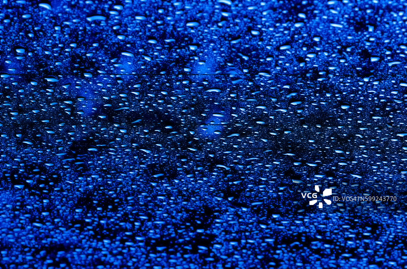 抽象的abd背景模糊了玻璃蓝色的水滴。图片素材
