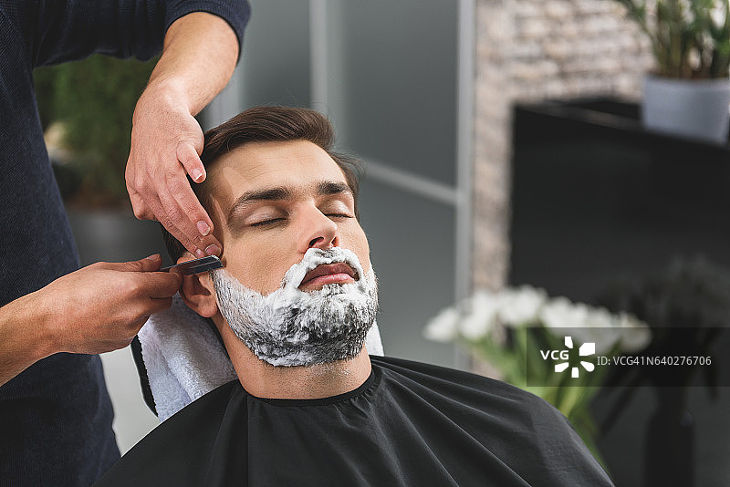 专业理发师为客户剃须图片素材