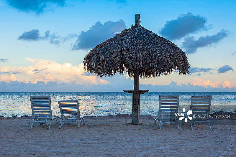 日落海滩上的日光浴椅和雨伞图片素材