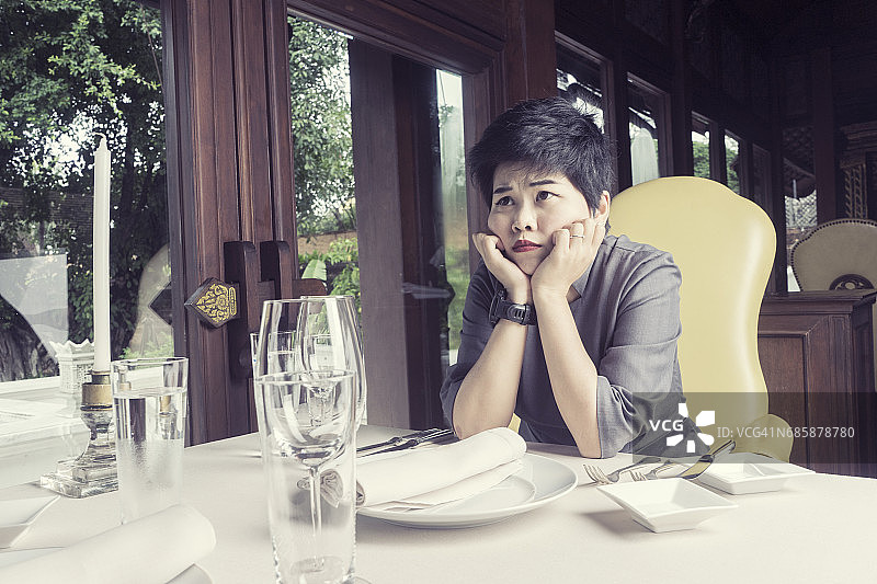 选择性焦点亚洲女性无聊的等待男朋友或亲密的朋友在餐厅图片素材