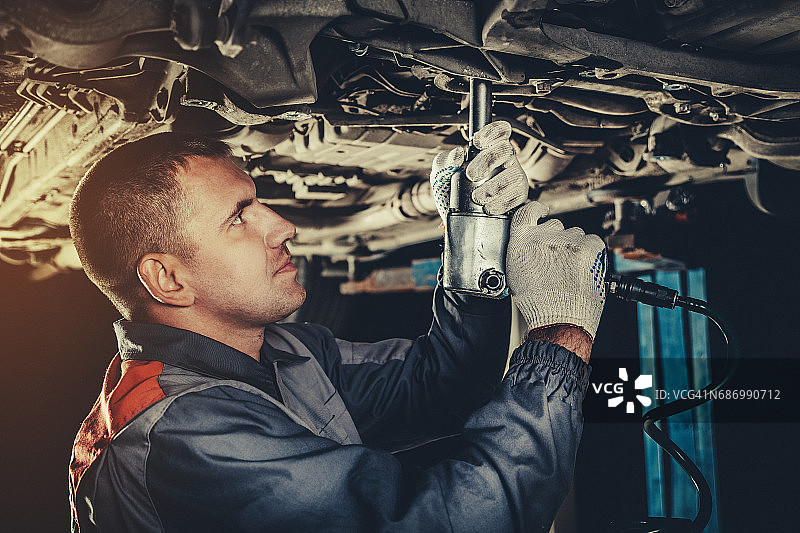 在汽车修理厂修理汽车的专业机械师图片素材