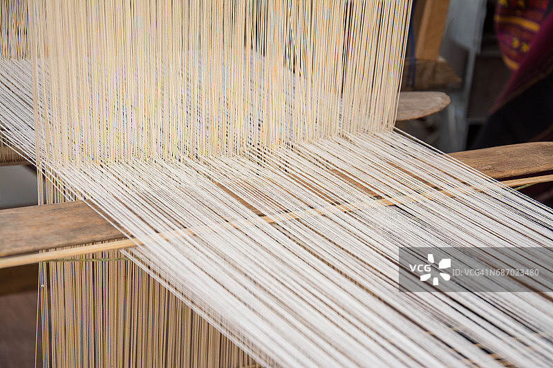 妇女在手工织布机上以传统方式织造丝绸。泰国图片素材