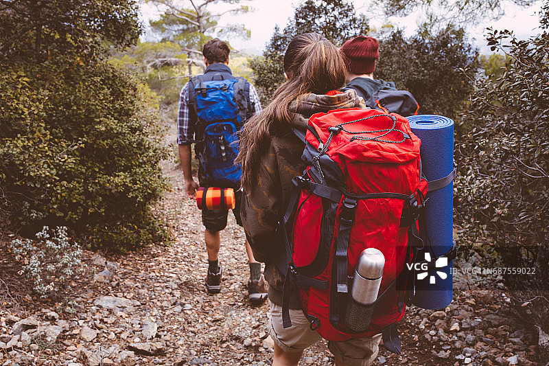 一群背着背包的朋友在森林里徒步旅行图片素材