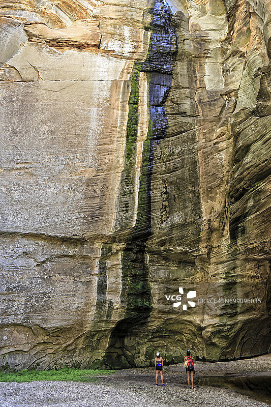 两个女孩站在亚利桑那州科科尼诺国家森林圣丹斯峡谷的砂岩悬崖下图片素材