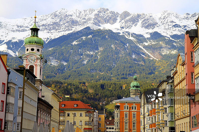 奥地利因斯布鲁克的旧城建筑，金色的秋天全景和田园诗般的北蒂罗尔白雪覆盖的卡温德尔山脉图片素材