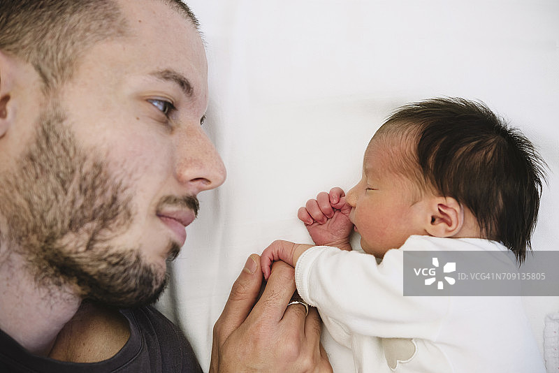 新生女婴握着父亲的手指图片素材