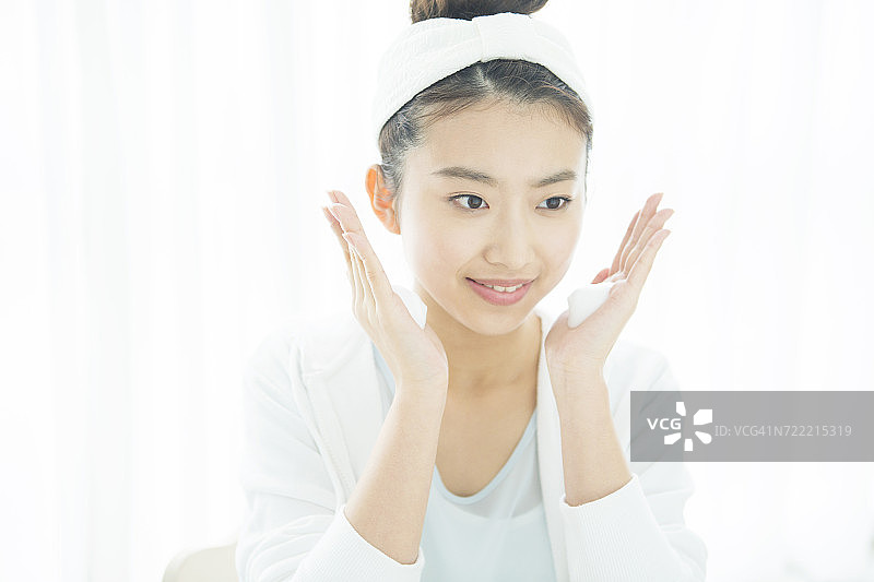 年轻女子用肥皂泡沫洗脸图片素材