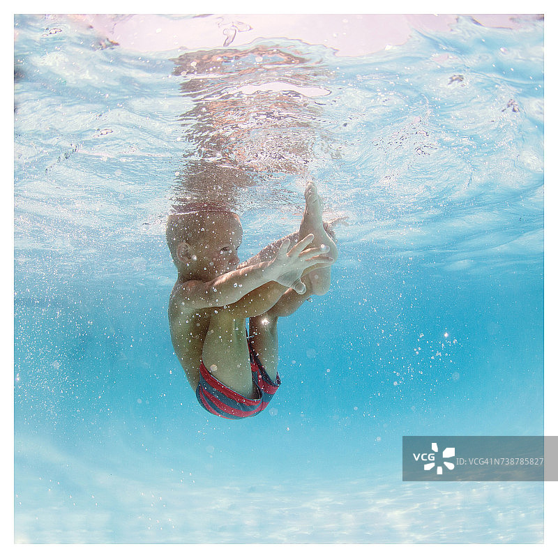 一个男孩跳进游泳池的水下视图图片素材