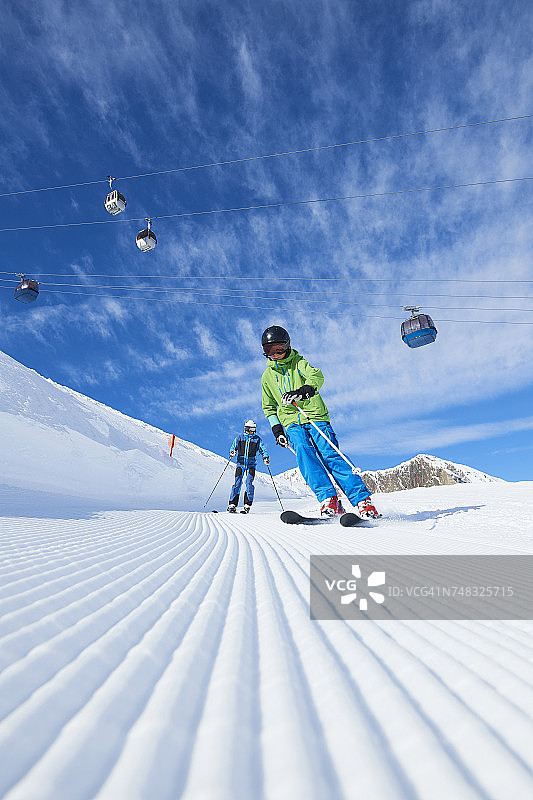父亲和儿子在滑雪度假，Hintertux, Tirol，奥地利图片素材