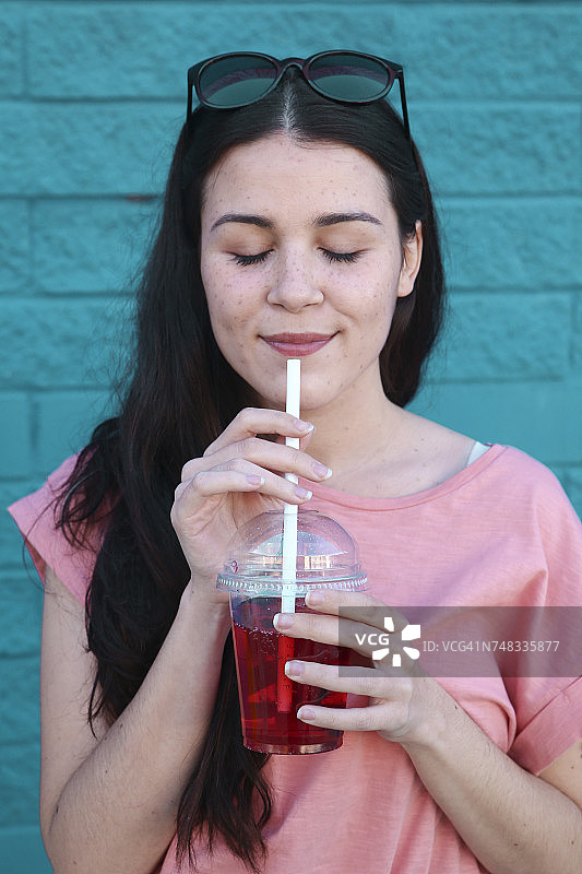 年轻女子喝软饮料的肖像图片素材
