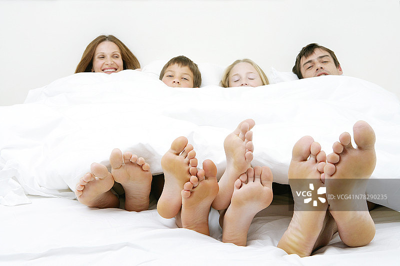 一家人光着脚睡在床上图片素材