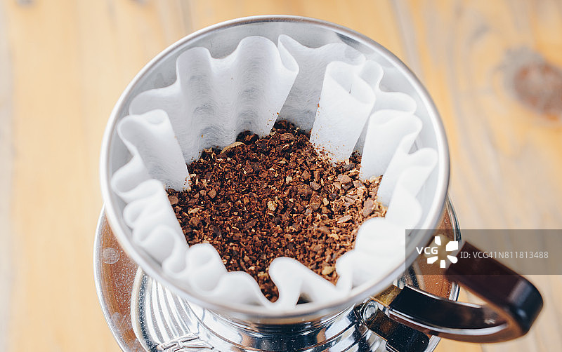 在煮咖啡之前，将咖啡粉放入滤纸中。图片素材