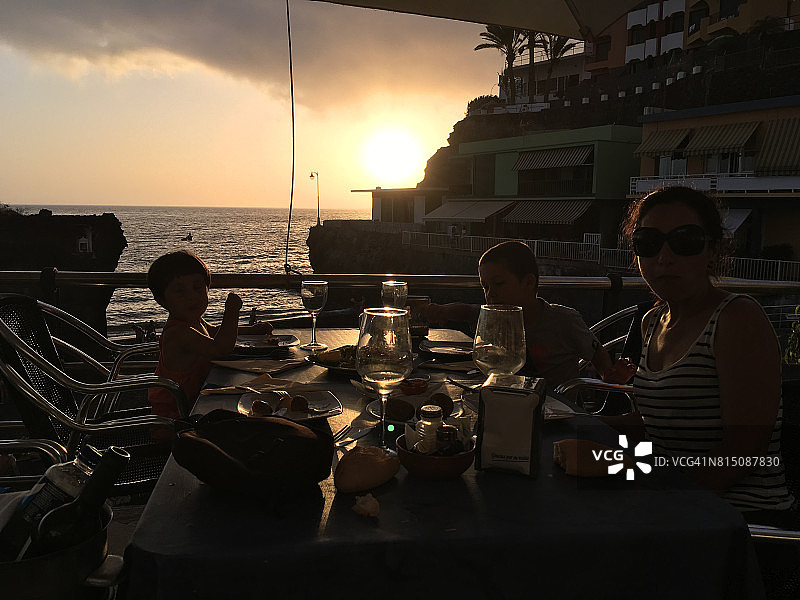 日落时分，母亲和孩子们在纳奥斯港用餐。拉帕尔马岛，加那利群岛，西班牙图片素材