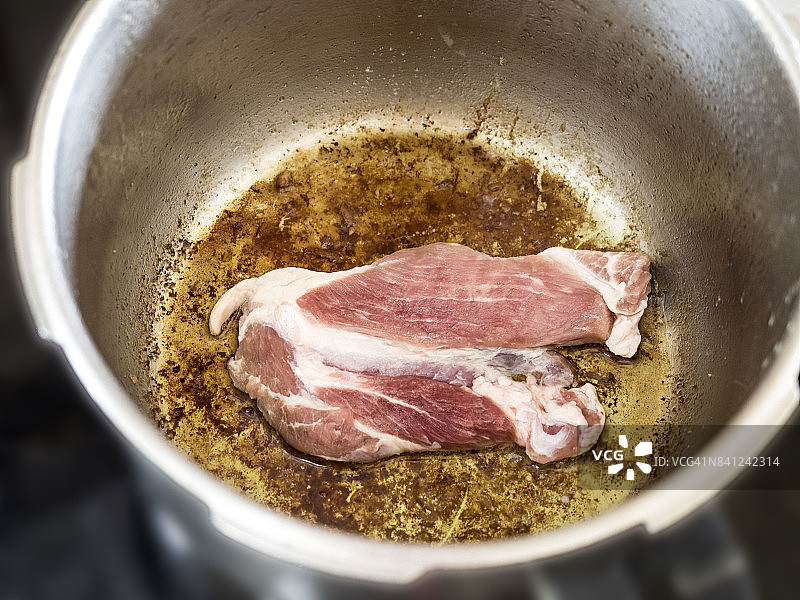 准备一种传统的蔬菜与肉炒猪肉在炖锅。西班牙图片素材