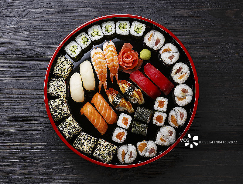 寿司手握寿司和卷在传统的日本黑色寿司圆盘子图片素材