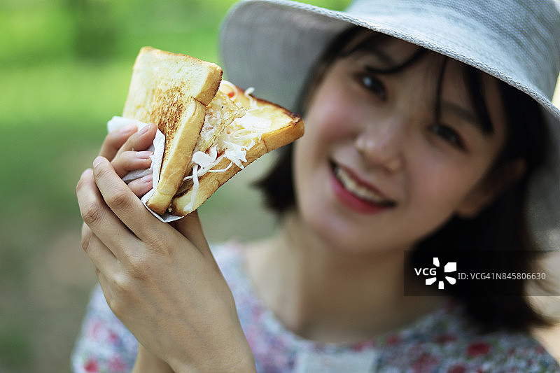 微笑着拿着面包的女人图片素材