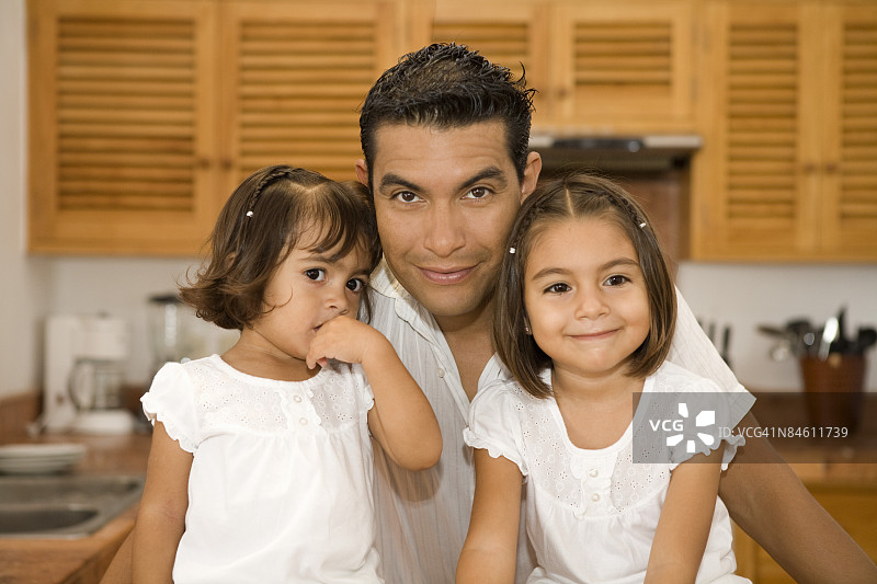 一个男人和他的女儿们在厨房的画像图片素材