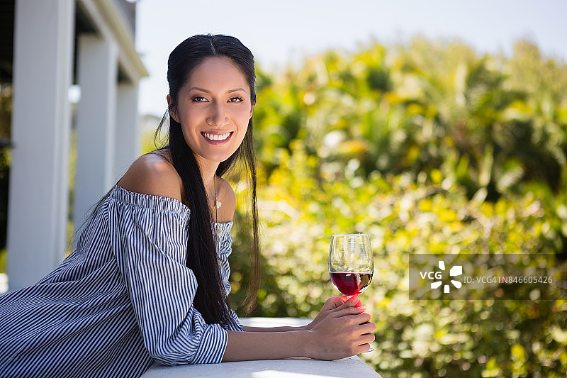 自信的女人拿着红酒杯站在餐厅图片素材