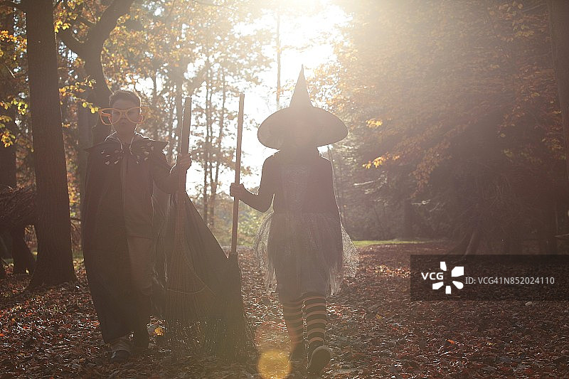 年轻的男巫和女巫在阳光下行走。图片素材