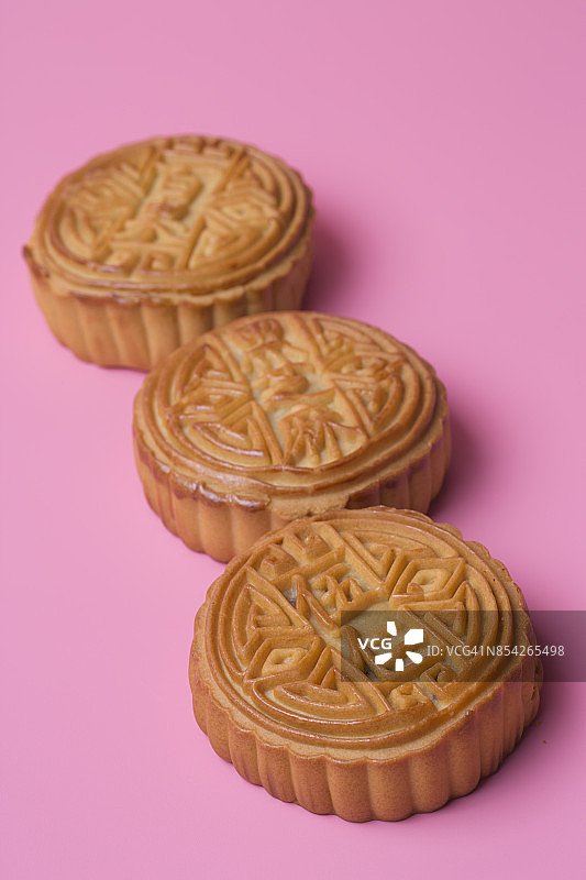 粉红色背景上的月饼。中国传统食物。图片素材