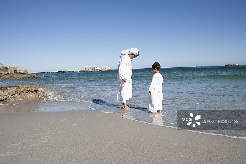 沙滩上的阿拉伯男人和男孩。图片素材