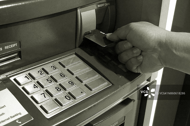 人用手插入自动柜员机的黑白卡图片素材