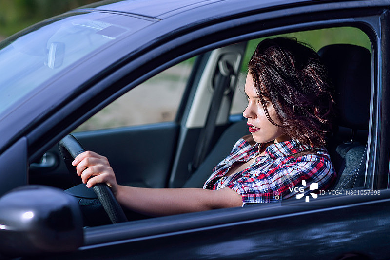 年轻女子高速驾驶汽车的侧面肖像图片素材