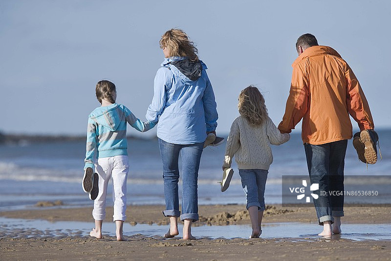 一家人赤脚走在爱尔兰布雷塔斯湾的海滩上图片素材