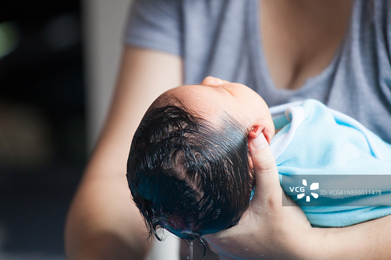 可爱的亚洲新生女婴在洗澡。妈妈在清洁她婴儿时期的头发。图片素材