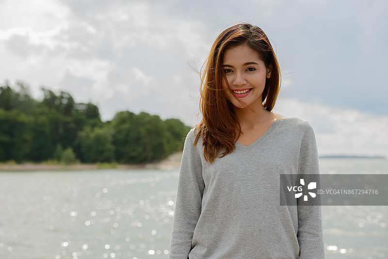 年轻美丽的亚洲女人对风景如画的湖在图尔库芬兰图片素材