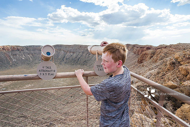一个小男孩在观测点用望远镜看东西图片素材