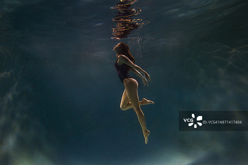 年轻女性模特在游泳池水下的肖像。图片素材