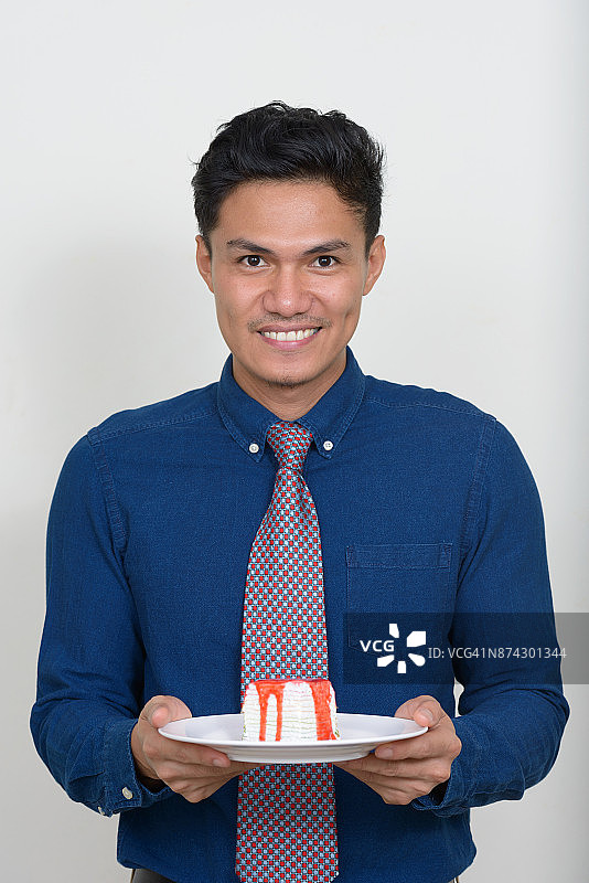 年轻的亚洲商人穿着蓝色纽扣衬衫对抗白色的背景图片素材