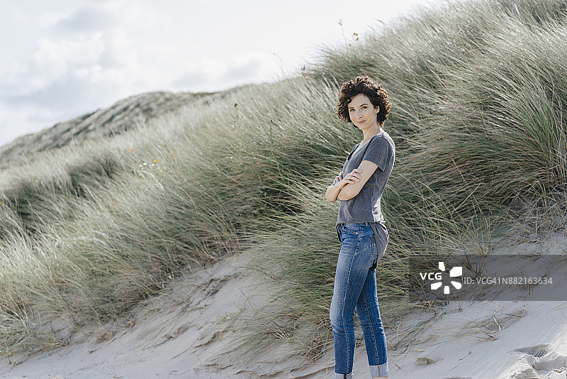 一个自信的女人站在沙滩上的肖像图片素材