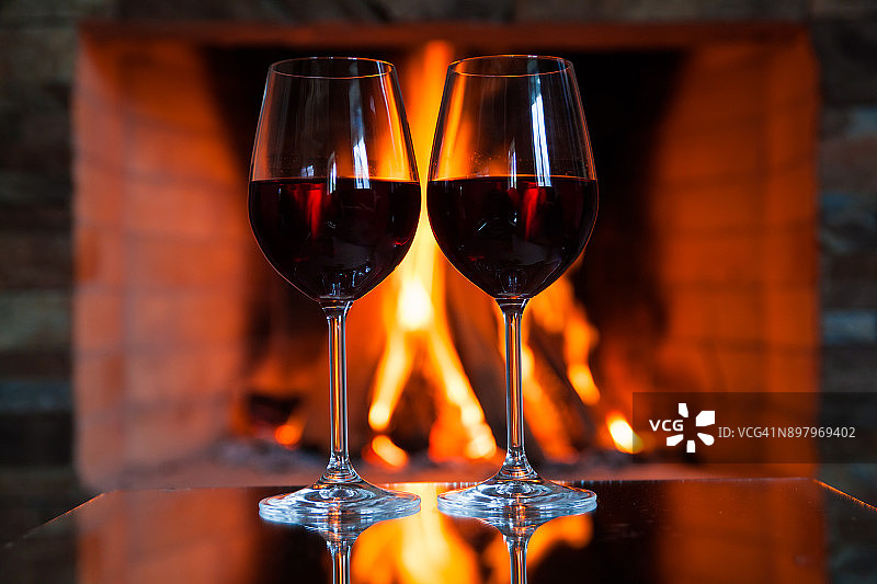 两杯红酒放在壁炉旁边图片素材