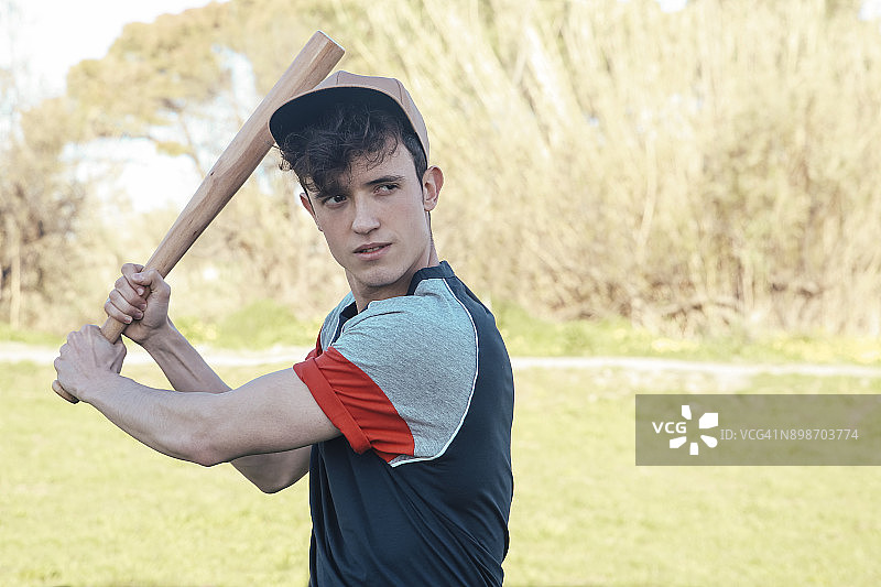 公园里一个年轻人拿着棒球棒的肖像图片素材