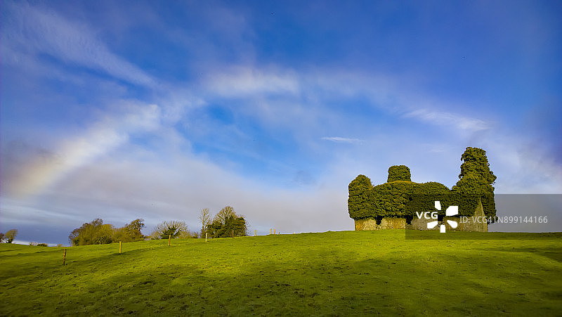 爱尔兰蒂珀雷里的古老教堂旁边美丽的爱尔兰田野上的彩虹景观图片素材