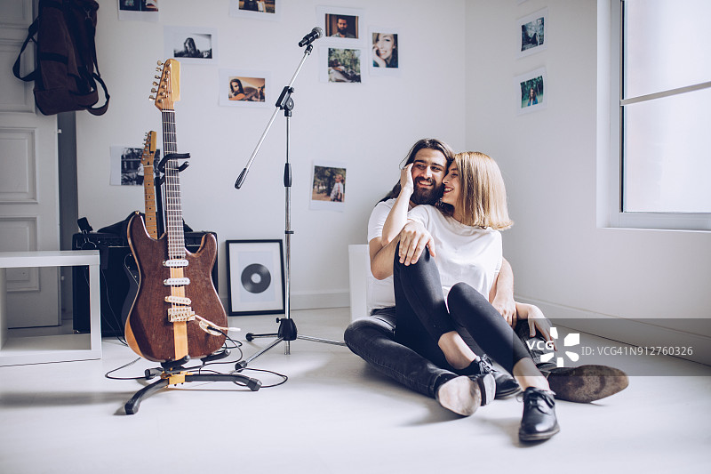 一对可爱的年轻夫妇坐在音乐工作室里图片素材