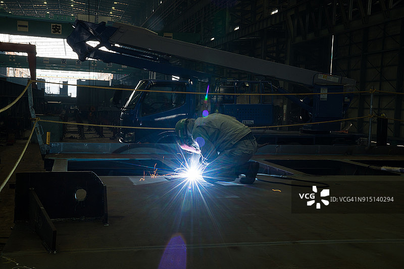 焊接大型货船零件的造船工人图片素材