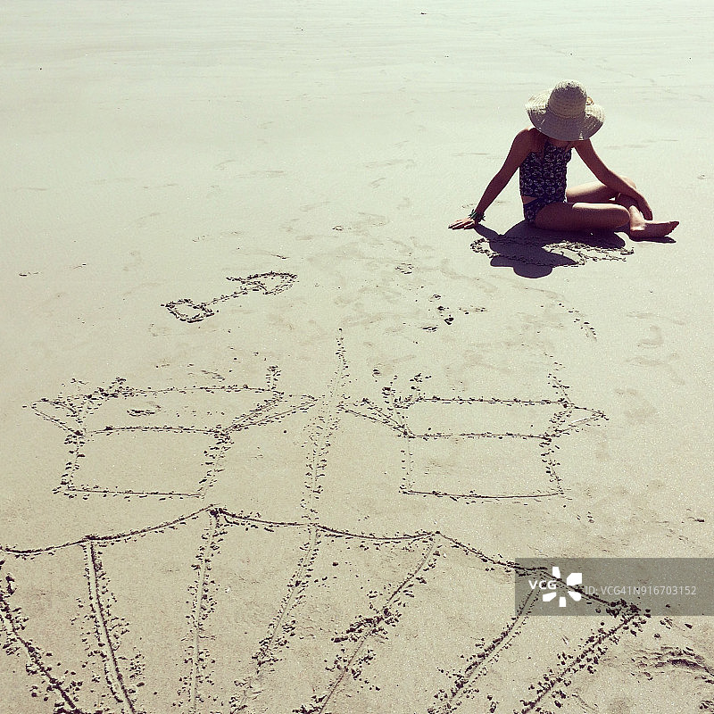 在沙滩上画画的小女孩图片素材